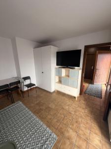 a living room with a flat screen tv and a table at Appolo in Vouvry