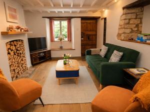 a living room with a green couch and a tv at Burford Apple in Burford