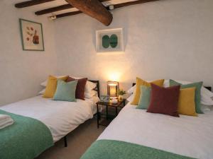 two beds sitting next to each other in a room at Burford Apple in Burford