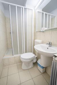 a bathroom with a toilet and a sink and a shower at Hotel Apollo in Mamaia