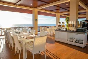 a restaurant with a table and chairs and the ocean at El Mar Resort in Sampong