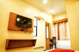 a room with a flat screen tv on the wall at Qubehotelinn in Cochin