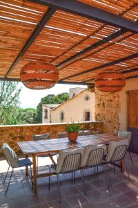 a patio with a table and chairs under a wooden pergola at Mas Salvador Rural Experience in Llagostera