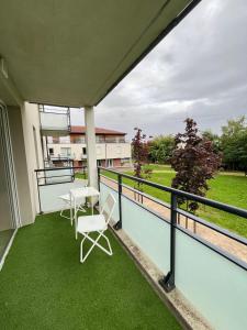 a balcony with green grass and a table and chairs at Villeneuve, in Villeneuve d'Ascq