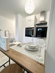 a kitchen with a table with two wine glasses on it at Villeneuve, in Villeneuve d'Ascq +4 photos