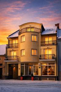 a large building with a sunset in the background at Hotel Vila Ariston in Osijek