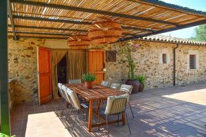 a wooden table and chairs on a patio at Mas Salvador Rural Experience in Llagostera