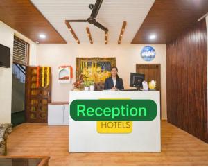 a woman sitting at a reception desk in a room at Hotel Villa Getaway in New Delhi