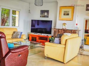 a living room with two chairs and a television at Diamante Villa Mijas in Mijas