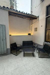 a patio with two chairs and a bench and a table at Casa Bago in Ivrea
