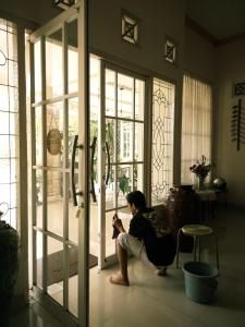a woman sitting on the floor in front of a door at HOME 88 Feels Like Home in Sleman