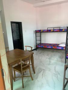 a room with a table and a desk and bunk beds at Chandani Hostel in Galle +6 photos