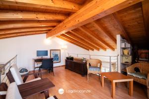 a living room with wooden ceilings and a table and chairs at Appartamento Diana in Salò