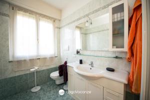 a bathroom with a sink and a toilet and a mirror at Appartamento Diana in Salò +20 photos