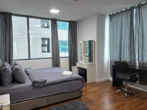 a bedroom with a bed and a desk with a computer at STAR Hotel Apartment in Kuala Lumpur