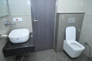 a bathroom with a white toilet and a sink at The Carnation Mound in Haldwāni +41 photos