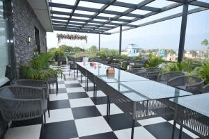 a restaurant with tables and chairs on a checkered floor at The Carnation Mound in Haldwāni