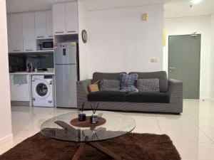 a living room with a couch and a glass table at STAR Hotel Apartment in Kuala Lumpur