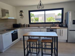 a kitchen with a table and some stools in it at Villa U Picculu in Lecci