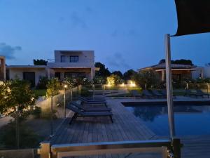 a swimming pool with lounge chairs in front of a building at Villa U Picculu in Lecci