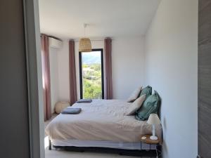 a bedroom with a large bed with a window at Villa U Picculu in Lecci +18 photos
