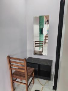 a room with a mirror and a chair and a table at Hill view cottage cj in Devikolam +12 photos