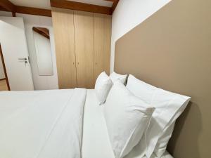 a bed with white sheets and pillows in a room at Grape Escape, By Home Match in Palmela