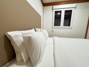 two white beds in a room with a window at Grape Escape, By Home Match in Palmela