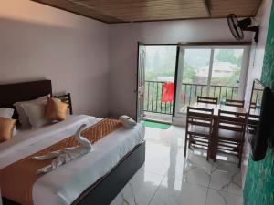 a bedroom with a bed with a view of a balcony at Hill view cottage cj in Devikolam