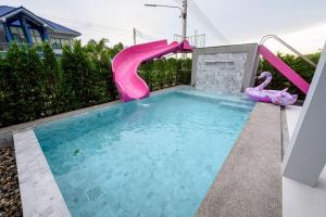 a swimming pool with a pink water slide at BanIngKhao Pool Villa Sriracha in Ban Hup Bon