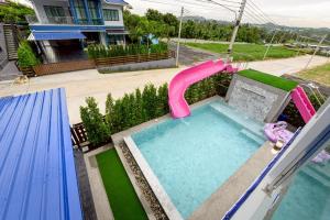 a swimming pool with a water slide in a backyard at BanIngKhao Pool Villa Sriracha in Ban Hup Bon