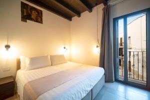 a bedroom with a bed and a large window at Le Contrade Di San Salvatore in Monopoli