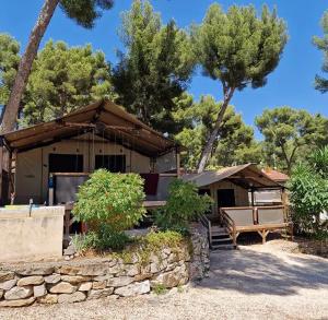 a house with a table and a bench in front of it at Camping de Ceyreste - Maeva in La Ciotat