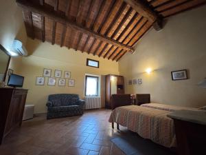 a bedroom with two beds and a chair in a room at Agriturismo Aggazzotti in Colombaro