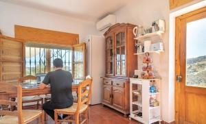 a man sitting at a table in a kitchen at Casa NATHIUM - Lujo Rural - Pooltina - Bbq - 4P - Vistas - Relax - Estrellas in Borge +33 photos