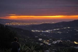 a man sitting on a hill watching the sunset at Casa NATHIUM - Lujo Rural - Pooltina - Bbq - 4P - Vistas - Relax - Estrellas in Borge