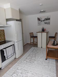 a kitchen with a refrigerator and a table with chairs at Lägenhet nära naturen Pralinette BB in Nykroppa +24 photos