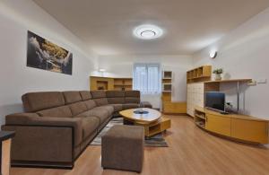 a living room with a couch and a tv at Chalupa u golfu Kořenec in Kořenec