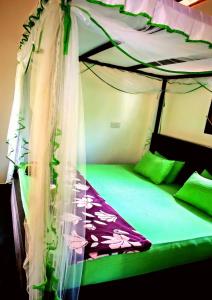 a bed with a canopy in a room at Rainforest River Bay in Deniyaya