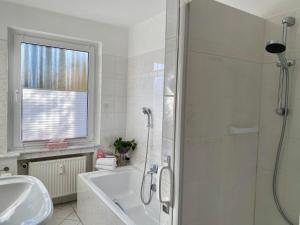a bathroom with a shower and a tub and a sink at Apartment am Golfplatz in Obernkirchen +10 photos