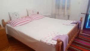 a bed with striped pillows on it in a bedroom at Vacation home in Virpazar