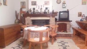 a living room with a fireplace and a table and chairs at Vacation home in Virpazar