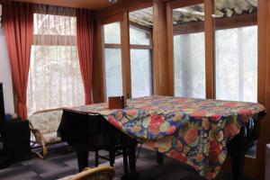a table with a quilt on it in a room with windows at ペンション愛宕道 in Kyoto