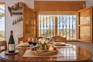 a dining room table with a bottle of wine and glasses at Casa NATHIUM - Lujo Rural - Pooltina - Bbq - 4P - Vistas - Relax - Estrellas in Borge