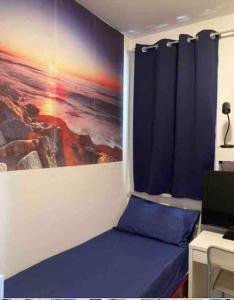 a bedroom with a blue bed and a painting on the wall at Splendida Alba in Tortoreto Lido