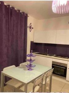 a kitchen with a table with a purple centerpiece on it at Splendida Alba in Tortoreto Lido