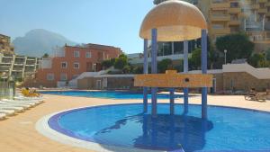 a swimming pool with a fountain in the middle of it at Apartamentos ORLANDO en Costa Adeje in Adeje