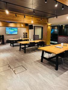 a conference room with wooden tables and a projection screen at Shoji Lake Hotel in Fujikawaguchiko