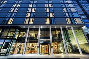 a tall glass building with a revolving door at Riu Plaza London The Westminster in London