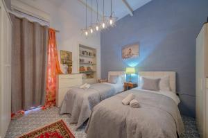 a bedroom with two beds and a blue wall at Charming Central 2BR Townhouse with Rooftop Terrace in St. Julianʼs